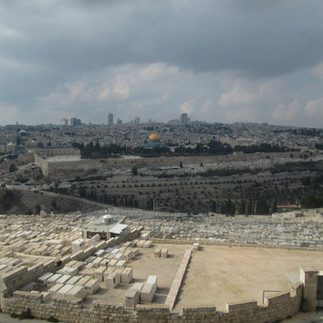 Looking across the Kidron Valley toward the Dome of the Rock and Old City walls. A high-angle view capturing the ancient Jewish graves on the Mount of Olives.
