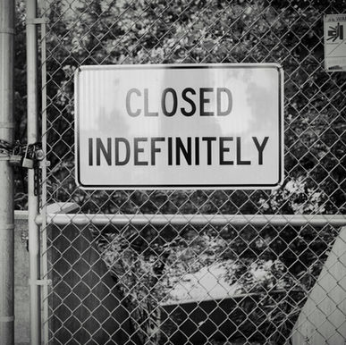 A "Closed indefinitely" sign on a chain link fence