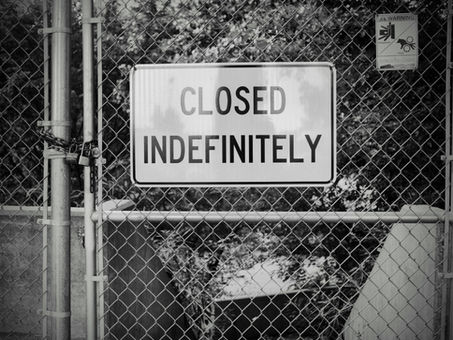 A "Closed indefinitely" sign on a chain link fence