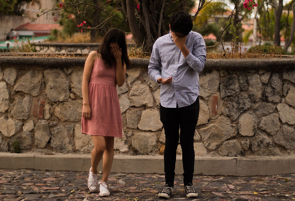 Couple sitting with emotional distance during a hard conversation.