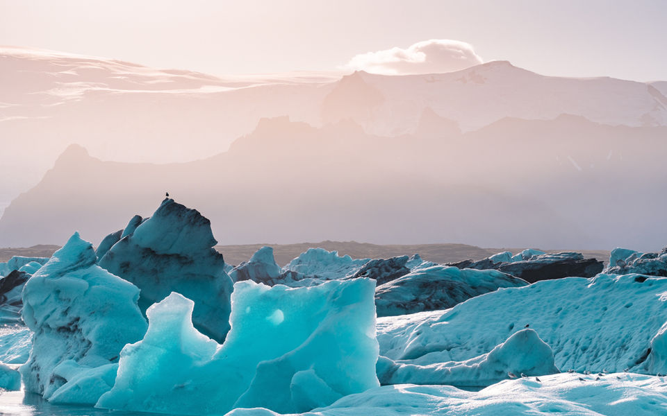 Iceberg galleggianti nella laguna glaciale di Jökulsárlón con montagne sullo sfondo