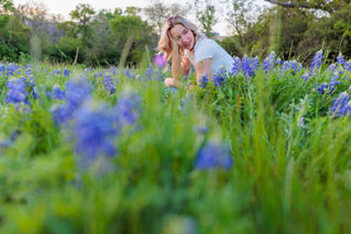 A teenager sitting peacefully among blooming wildflowers, reflecting on the quiet support, beauty, and abundance already present in nature.