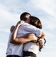 A couple hugging each other tightly after working with a trauma therapist