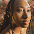 Image by Dylann Hendricks of a young black woman in three quarter profile posing for the camera.a