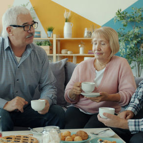 Three retired adults enjoying coffee and conversation at home