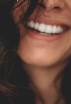Smiling adult with straight teeth after braces or aligners