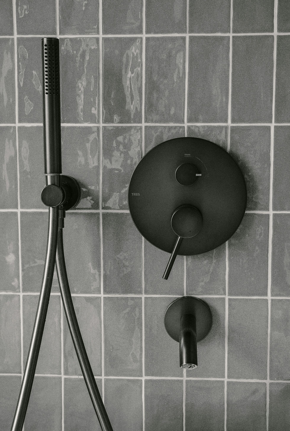 Modern bathroom with black fixtures and hardware — common bathroom design mistake due to water spots and scratches