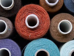 Spools of coloured textile yarn used to illustrate sustainable materials in running shoes