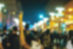 Young woman holding up peace sign at a protest