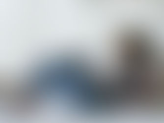 A young woman relaxes on her bed while using her laptop to shop online.