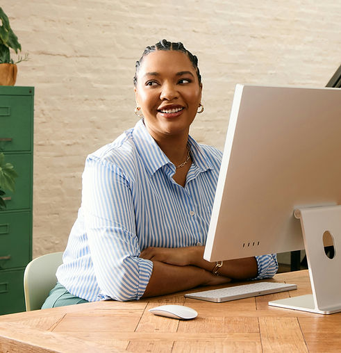 Professional Black woman in front of desktop smiling