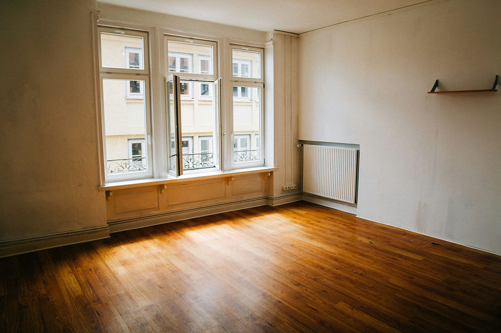 Empty room with large window and light flooring