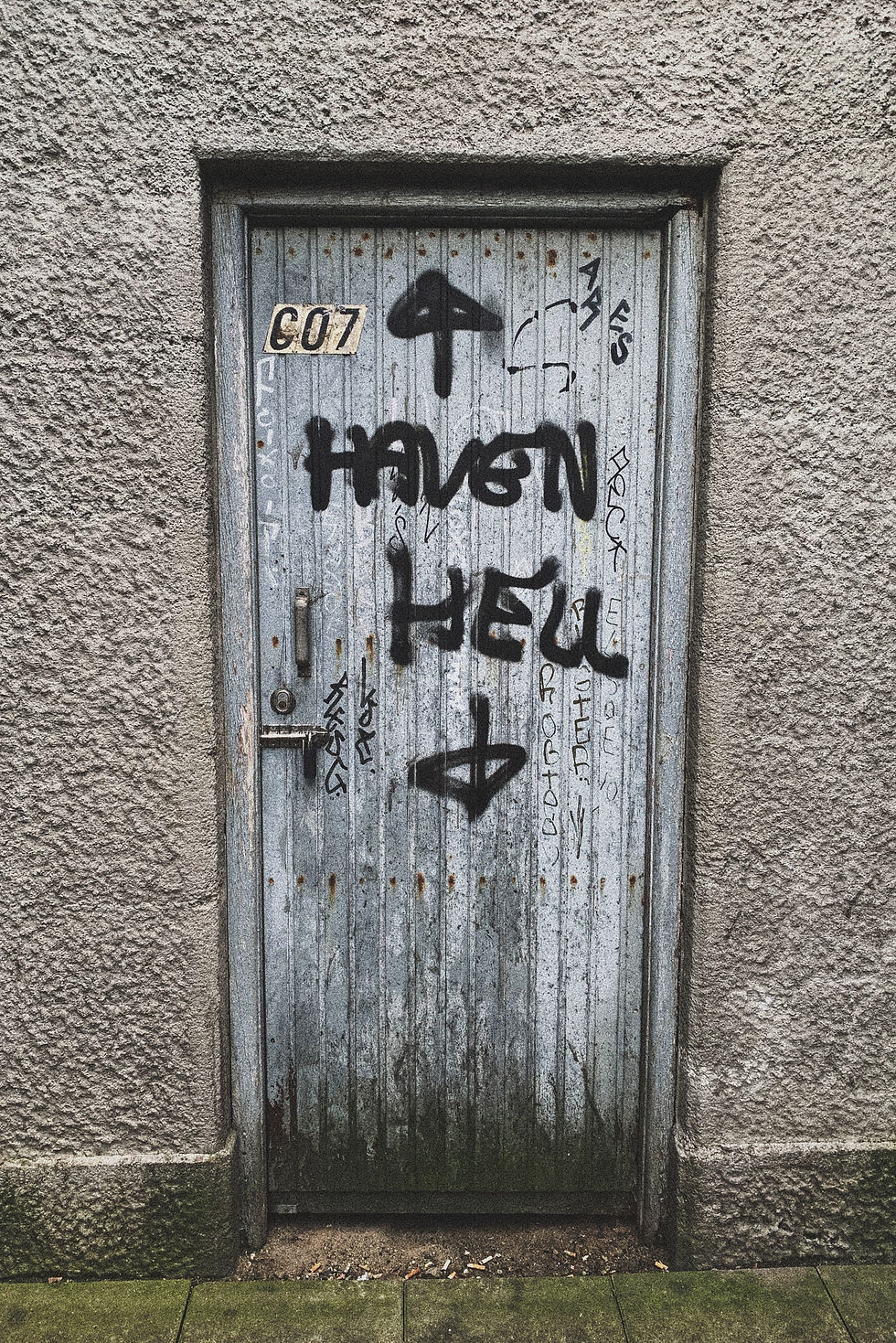 Door with spray paint on it reading "Haven" with an up arrow, and "Hell" with a down arrow.