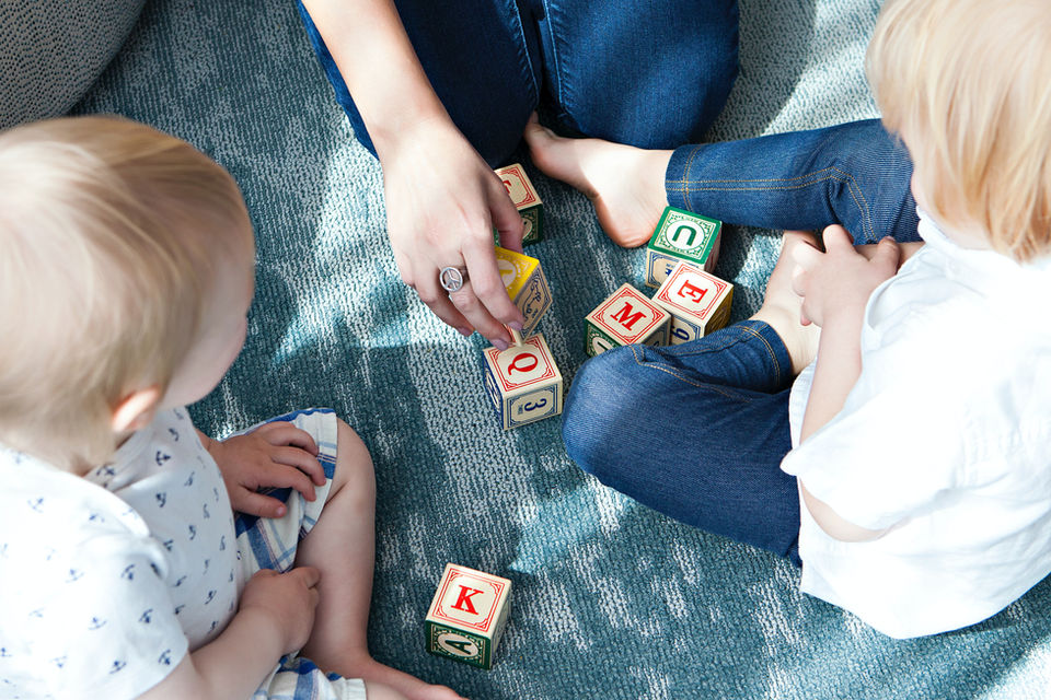 Newborn Photography by Blake Ferguson depicts a Mother Playing with Blocks alongside her two Babies in Ontario, Canada.