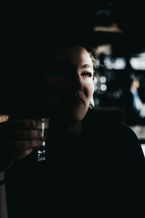 Image by Tanner Marquis of woman in shadow with a drink in her hand