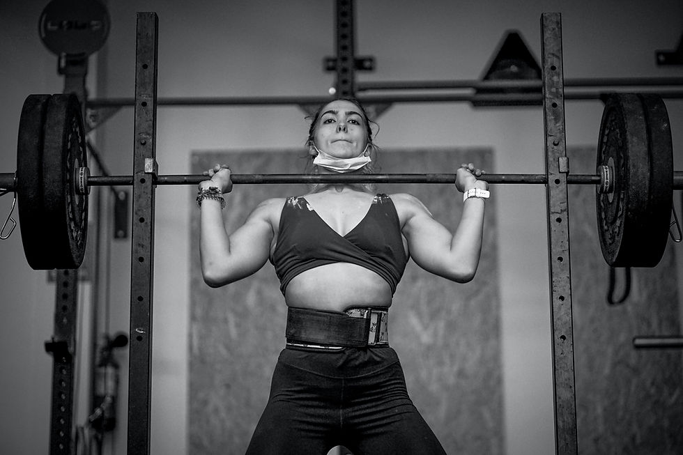 Very strong and athletic woman doing heavy shoulder press with barbell and Olympic weightlifting