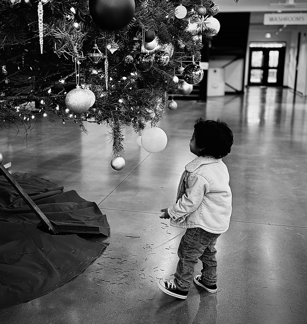 Child looking at Christmas tree - holiday wonder and faith moment by Jasmeen Hemmings