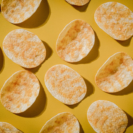 Crisps lined up on a yellow table