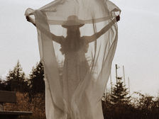 Frau mit transparentem Schal, der Wind hält diesen vor ihrem Körper