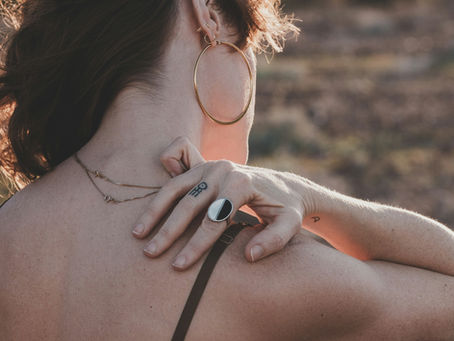 Woman in perimenopause holding her shoulder, illustrating the connection between hormonal changes and frozen shoulder pain from Vibrance Way