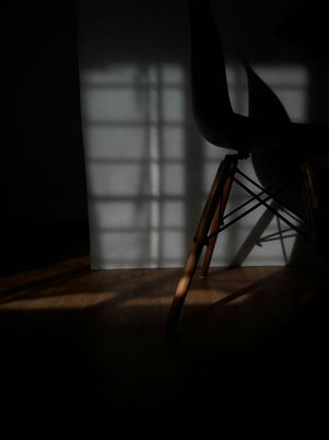 Warm minimalist sitting area sunlight casting shadows through a large window