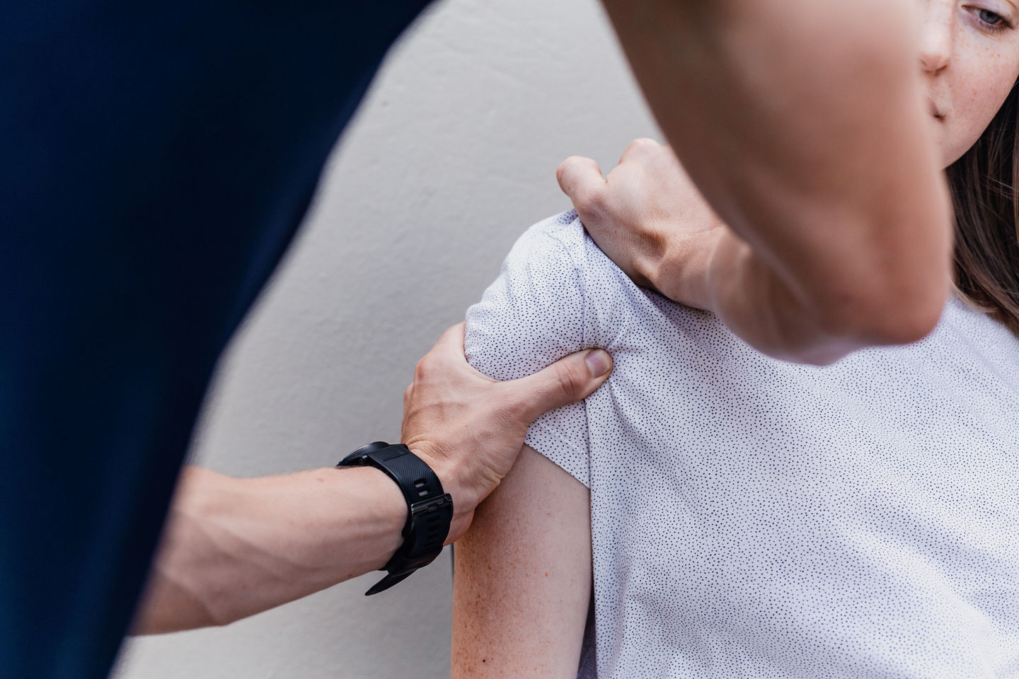 Physiotherapist testing a females shoulder injury