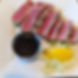 Medium-Rare Ahi Tuna coated in Sesame Seeds, served with Ginger Soy Dip and a lemon wedge