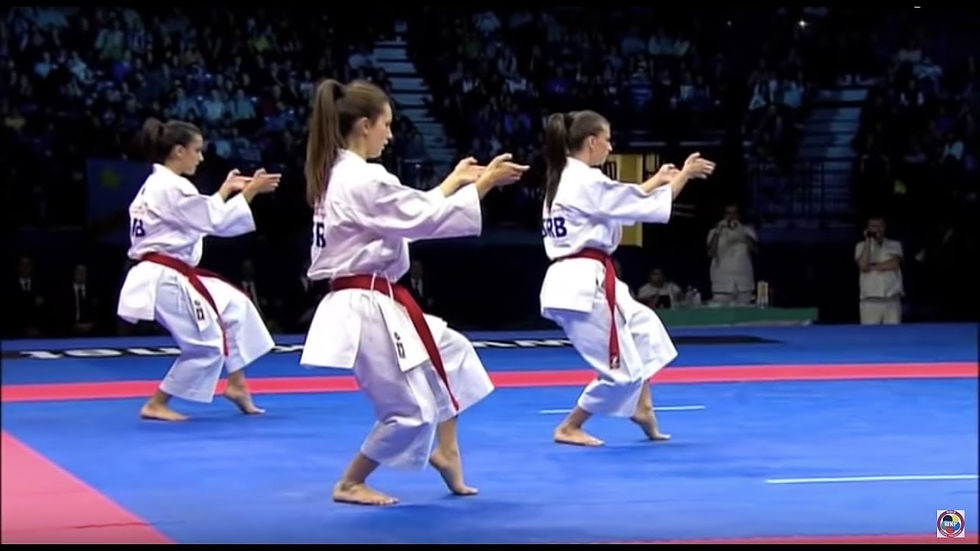 Three karateka demonstrate a form together